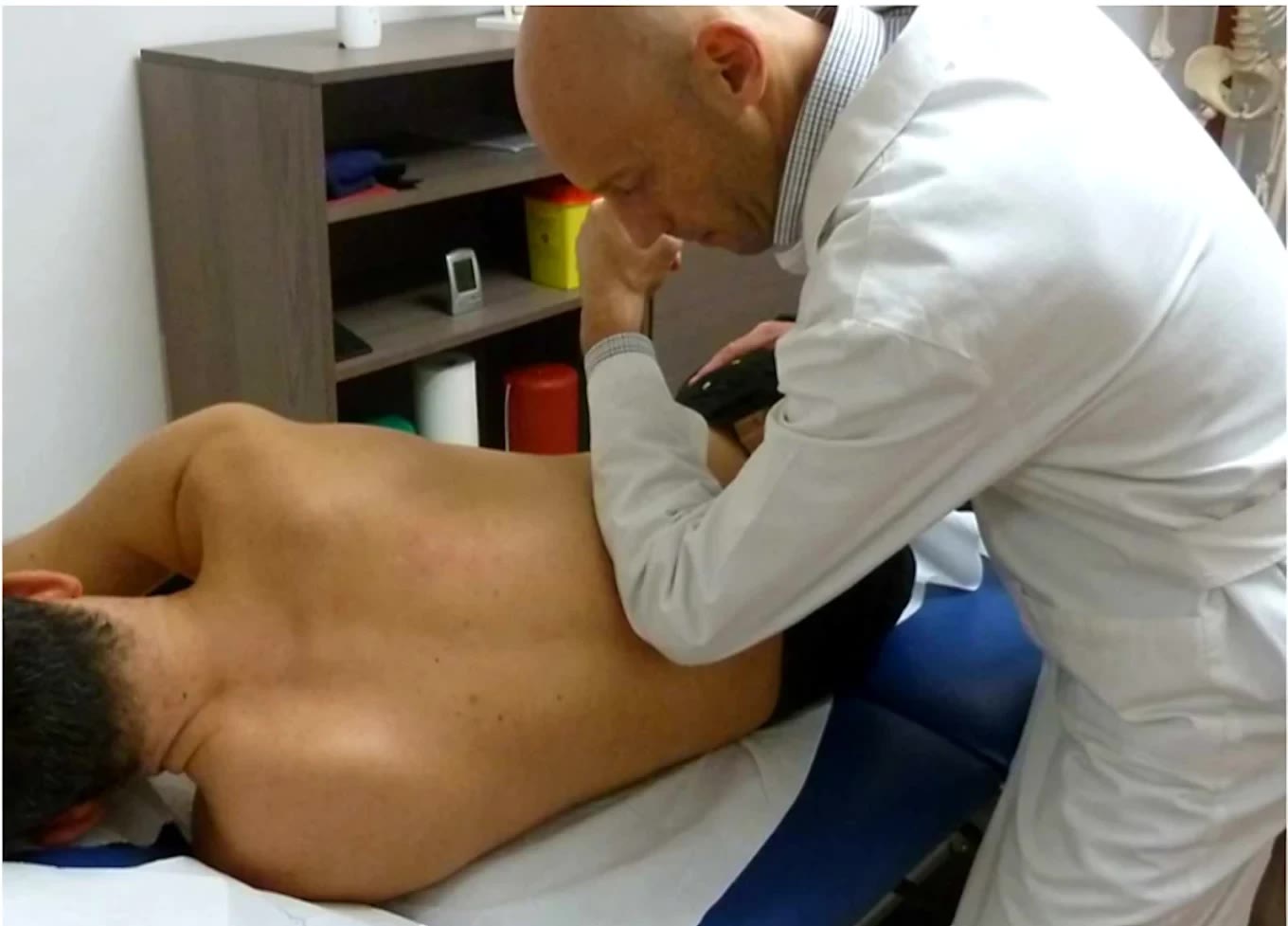 Paolo Leone tratta la spalla di un paziente sdraiato sul fianco